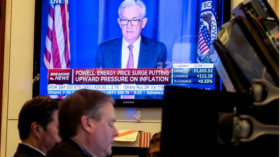 Traders work, as Federal Reserve Chair Jerome Powell is seen delivering remarks on a screen at the New York Stock Exchange (NYSE) in New York City, U.S., March 16, 2022
