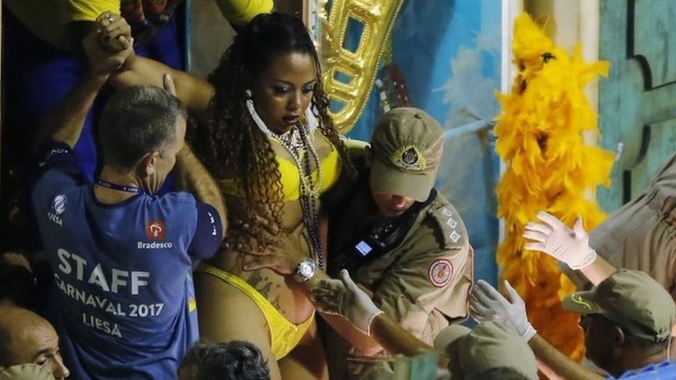 Пожарные и карнавальный персонал выносят женщину с поплавка после аварии во время выступления школы самбы Unidos da Tijuca во время празднования карнавала на Самбадроме в Рио-де-Жанейро, Бразилия, вторник, 28 февраля 201 г.