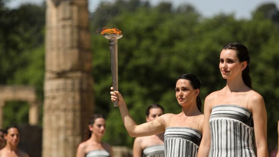 A woman holding the Olympic torch during a rehearsal of the opening ceremony
