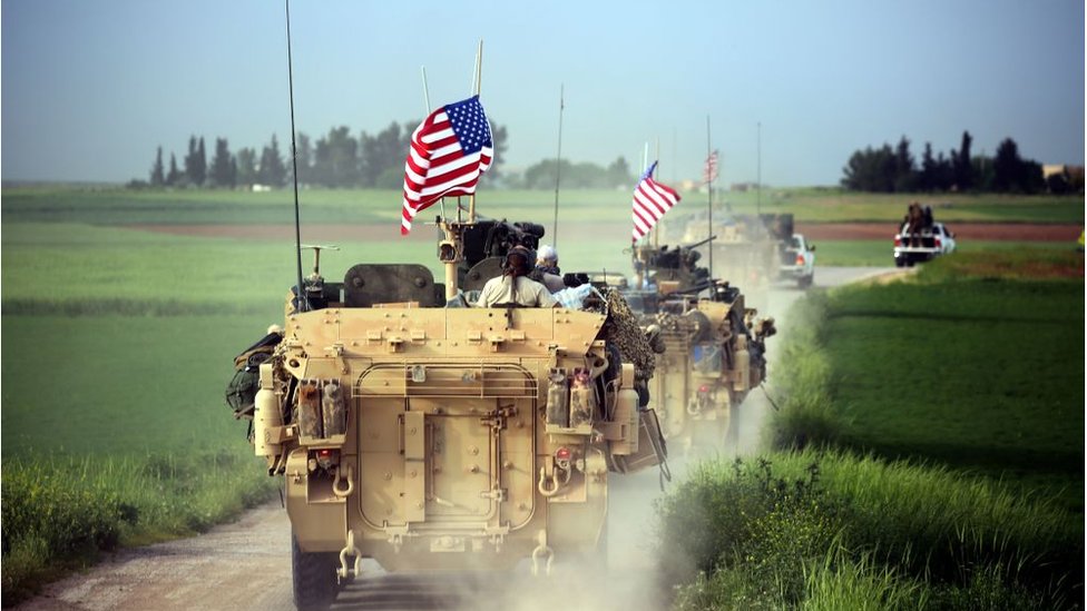 Силы США в сопровождении бойцов курдских отрядов народной защиты (YPG) едут на своей бронетехнике возле северной сирийской деревни Дарбасия на границе с Турцией 28 апреля 2017 г.