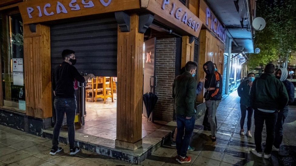 Un hombre cierra un comercio en Toledo, España.