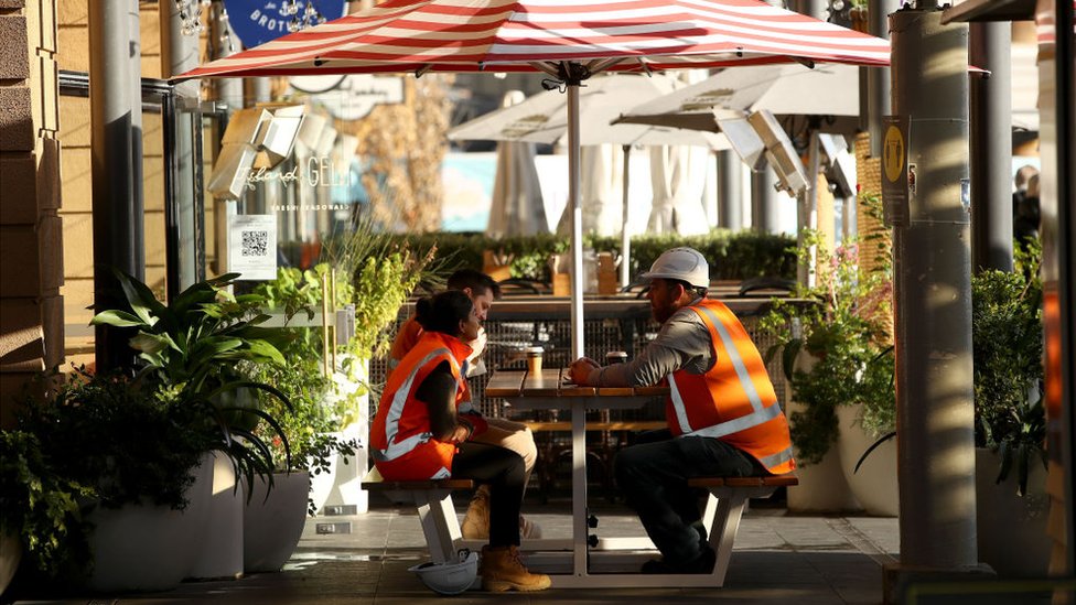 Construction workers sitting together, having a coffee break