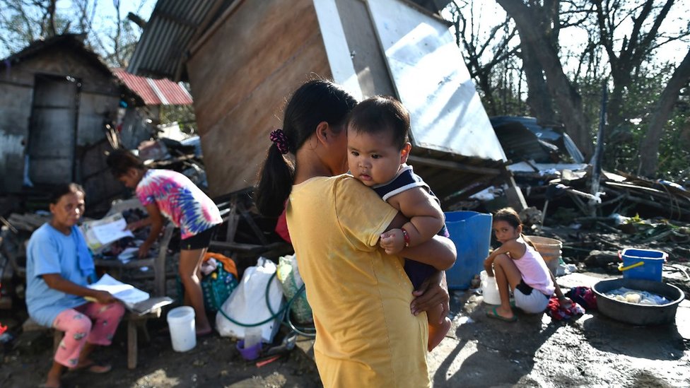 Residents gather next to their destroyed house in Carcar, Philippines` Cebu province on December 18, 2021, days after Super Typhoon Rai hit the city