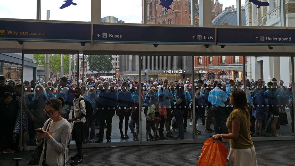 Люди ждут возле вокзала Кингс-Кросс в Лондоне, так как все услуги на вокзале и выходе из него были приостановлены