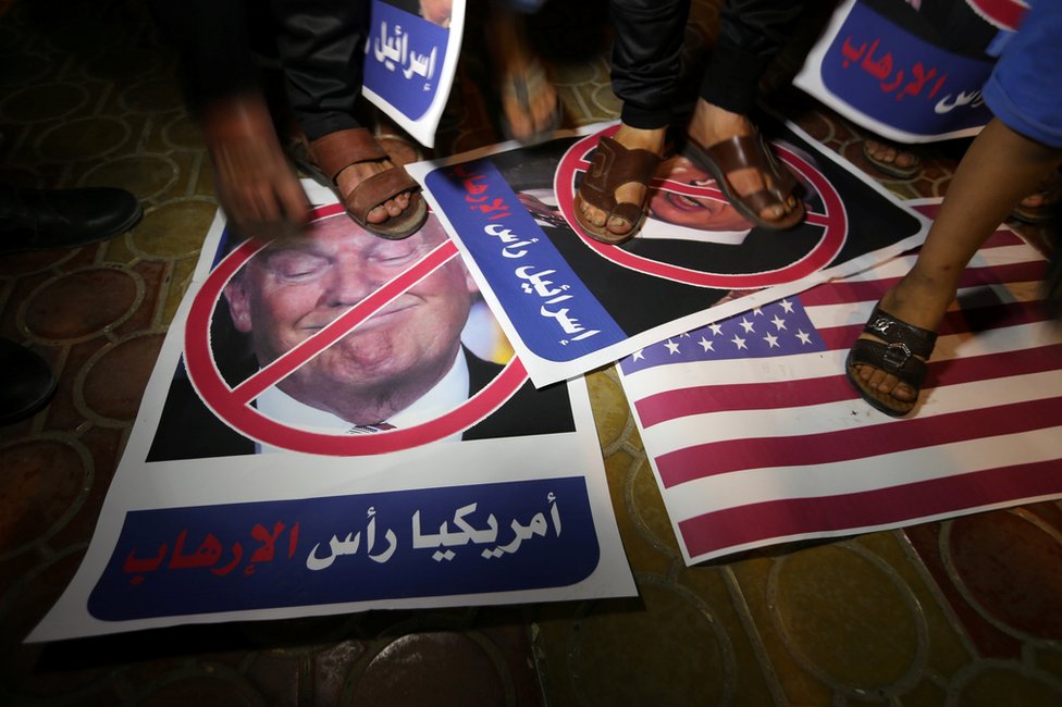 Палестинский демонстрант наступает на плакат с изображением Дональда Трампа в Рафахе на юге сектора Газа, 22 мая