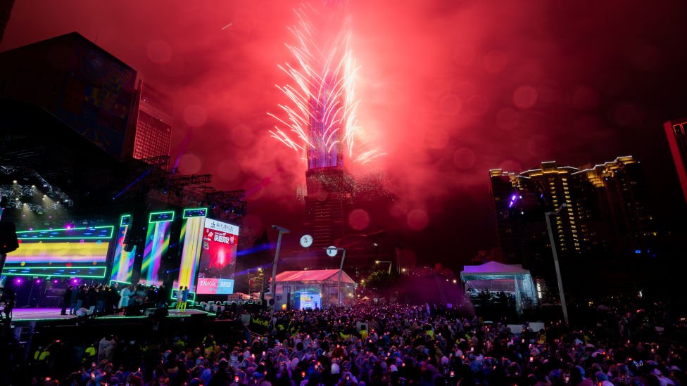 Orang-orang merayakan tahun baru di Taipei, Taiwan seiring kembang api menerangi cakrawala dari gedung Taipei 101.