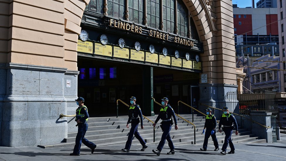 Police patrol outside Flinders Street Station during Melbourne's virus lockdown