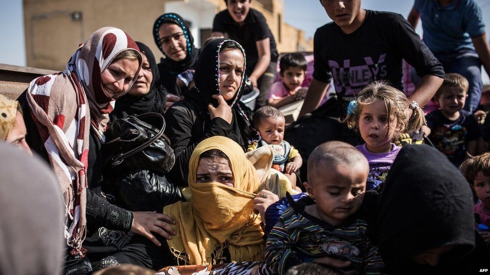 Сирийские беженцы пересекают границу с Турцией в условиях боевых действий между силами, возглавляемыми курдами, и боевиками Исламского государства в Тал Абьяд (26 июня 2015 г.)