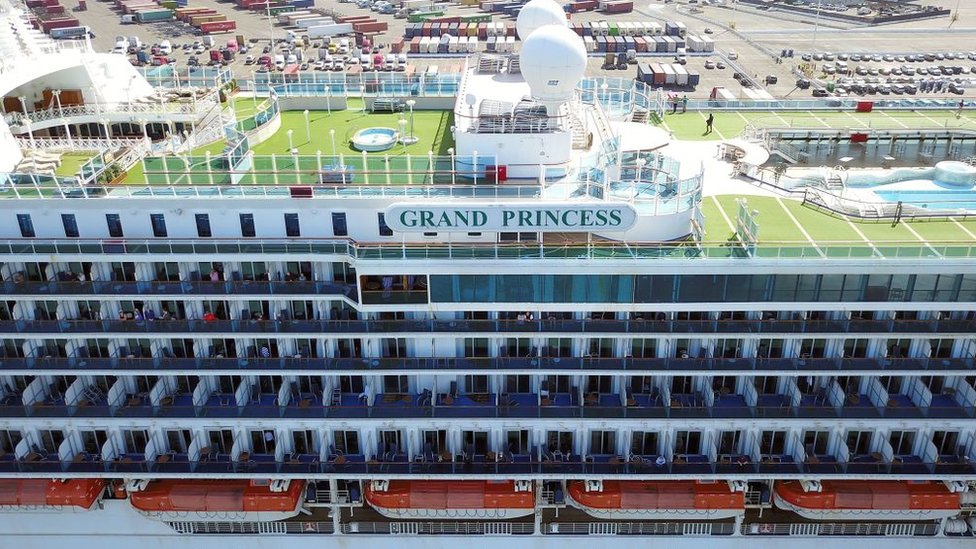 Пассажиры смотрят, как круизный лайнер Grand Princess пришвартовывается в порту Окленда в Окленде, штат Калифорния, 9 марта 2020 года