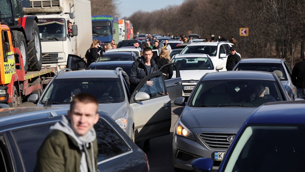 People wait in a traffic jam as they leave the city of Kharkiv, after Russian President Vladimir Putin authorised a military operation in eastern Ukraine