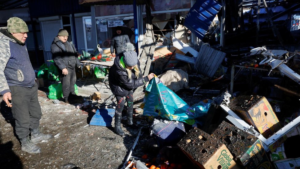 People remove debris at a food market following, what local Russian-installed authorities say, was a Ukrainian military strike in the course of Russia-Ukraine conflict in Donetsk, Russian-controlled Ukraine