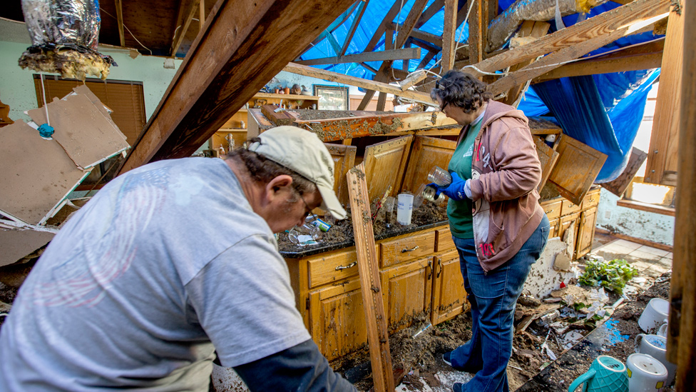 Una pareja examina los restos destrozados de la cocina de su casa en Longs, Florida