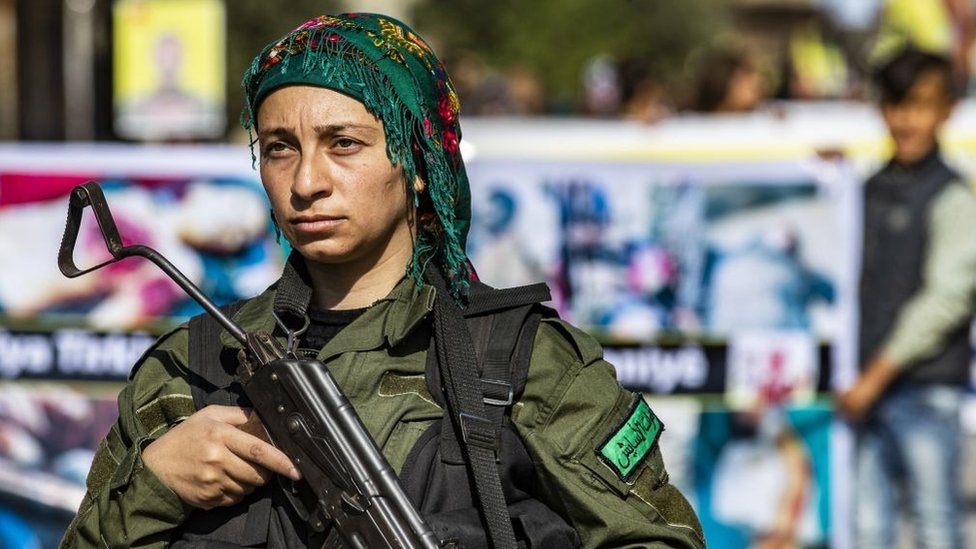 Член курдских сил внутренней безопасности стоит на страже во время акции протеста против турецкого нападения на северо-восток Сирии