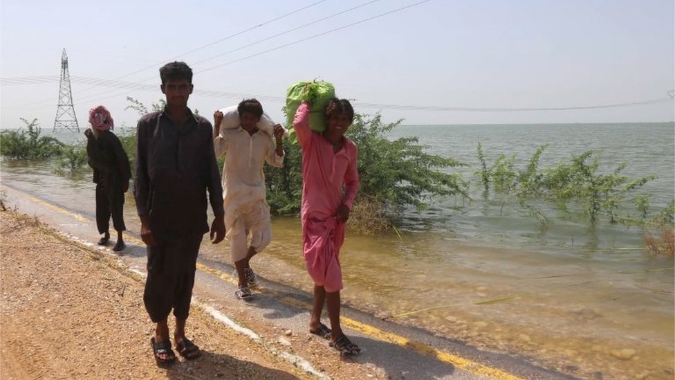 Pessoas se mudam para regiões mais altas depois que aldeias foram inundadas após um flanco ter sido aberto no lago Manchar para reduzir o transbordamento, no distrito de Jamshoro, província de Sindh, Paquistão, no dia 6 de setembro de 2022