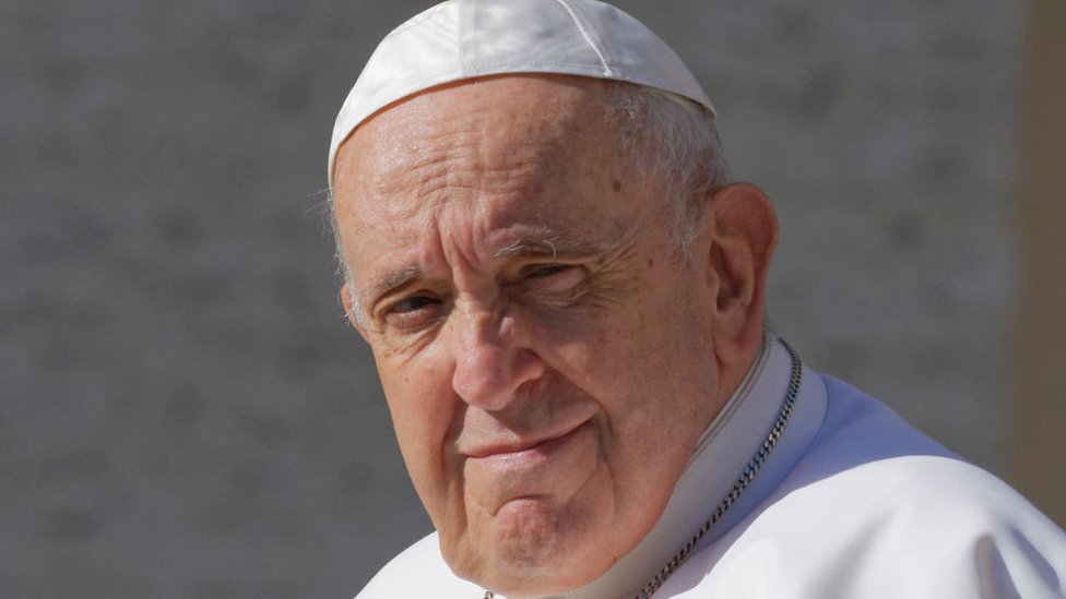 Fotografia colorida mostra o rosto do papa Francisco, um homem branco idoso com roupa branca