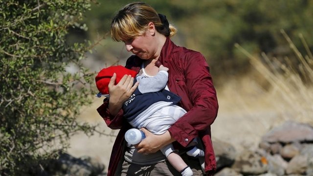 A Syrian migrant woman, holding a baby, on the Greek island of Lesbos
