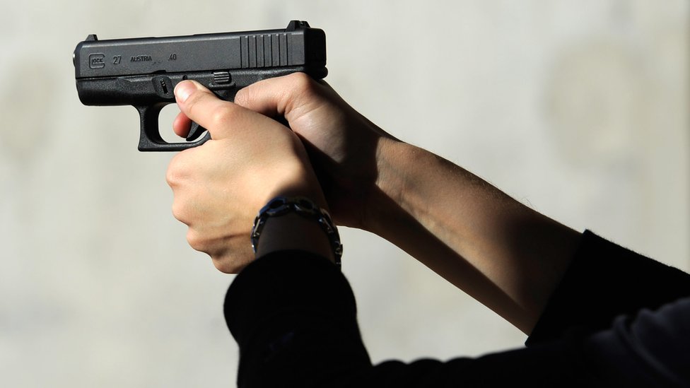 Unas manos de mujer sostienen una pistola de calibre .40