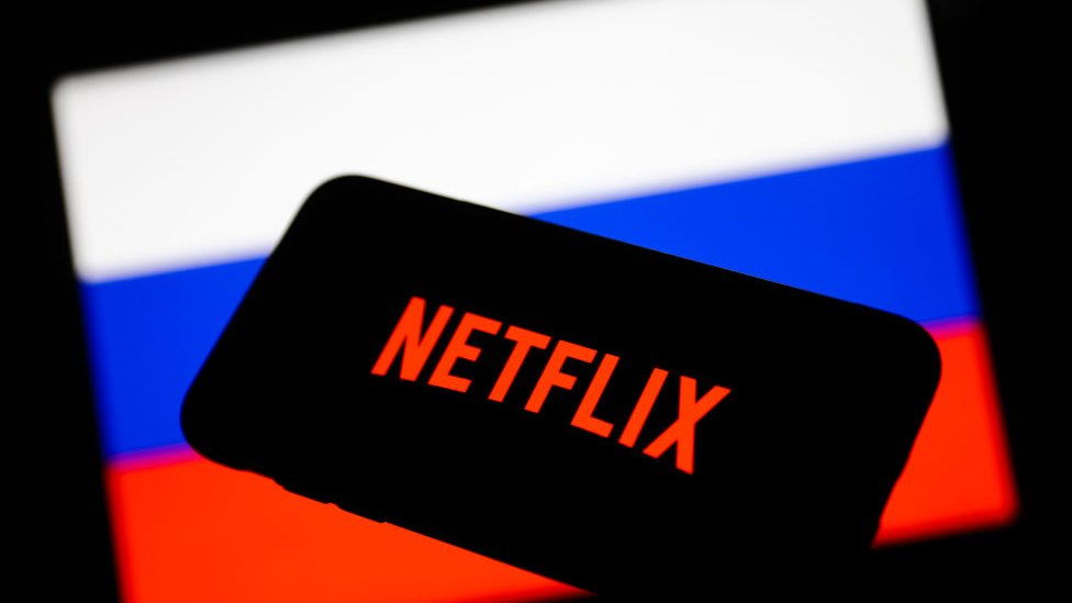Logo de Netflix con la bandera rusa detrás.