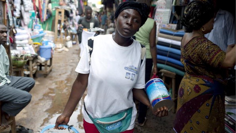 Фелисити, 20 лет, идет на центральный рынок, торгуя сухим молоком Oldenberger 8 августа 2009 года в Баменде, Камерун