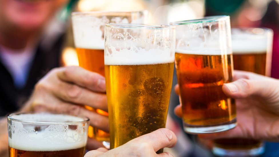 Personas brindando con cerveza.