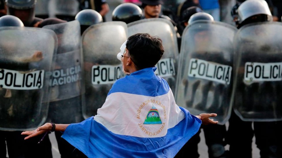 Manifestante cubierto con la bandera de Nicaragua