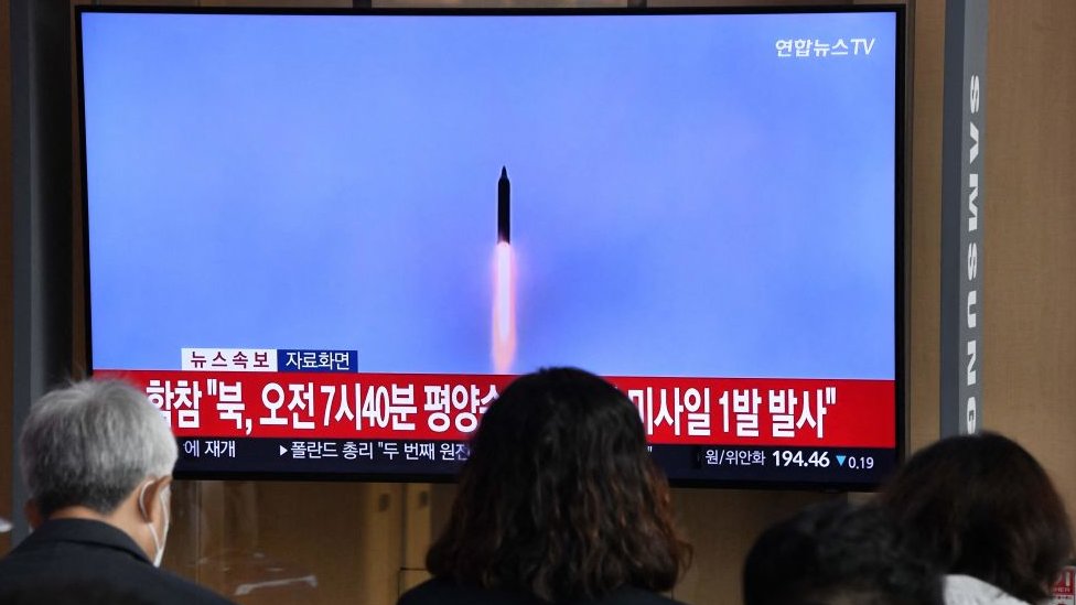 Pessoas assistem a uma tela de TV mostrando um noticiário com imagens de arquivo de um teste de míssil norte-coreano, em uma estação de trem em Seul, em 3 de novembro de 2022.