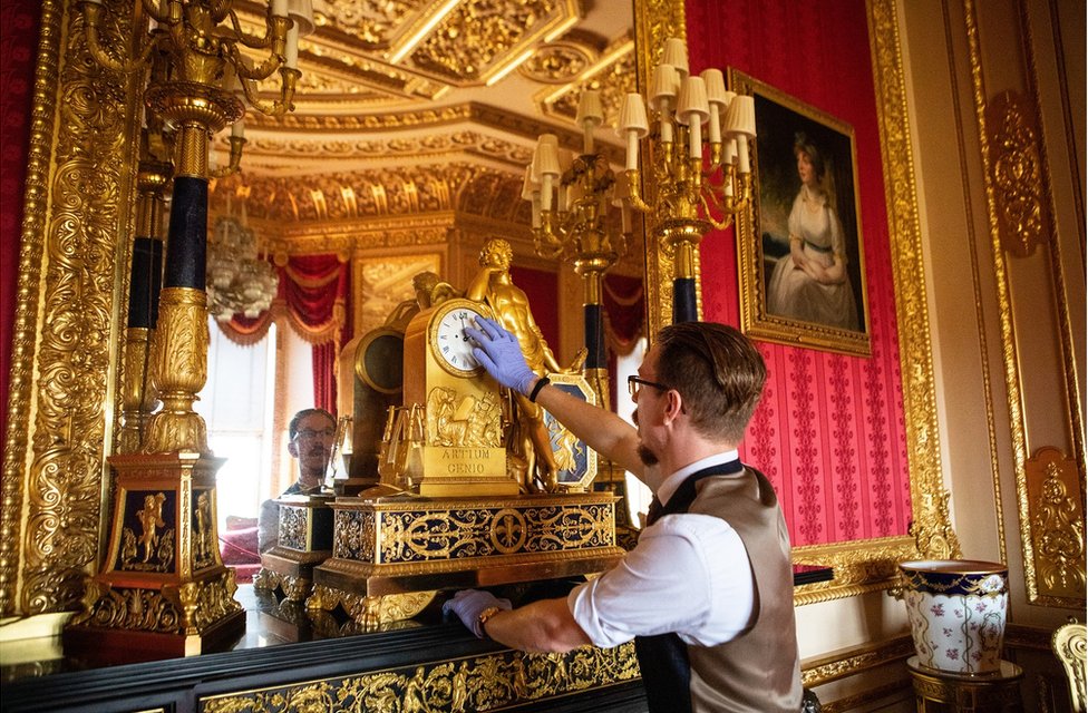 Fjodor changes the time on a clock in the Crimson Drawing Room