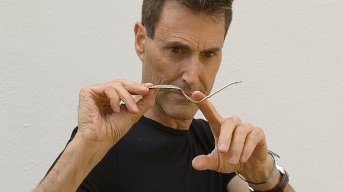 Uri Geller holding a bent spoon