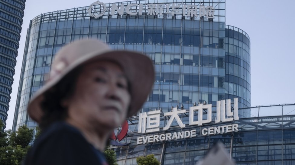 A woman walks past the Evergrande Center in Shanghai, China, 21 September 2021.
