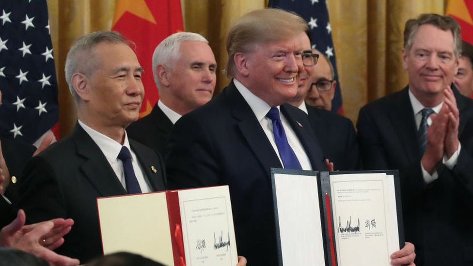 Президент США Дональд Трамп и вице-премьер Китая Лю Хэ задерживают подписанные соглашения о первом этапе торговой сделки.
