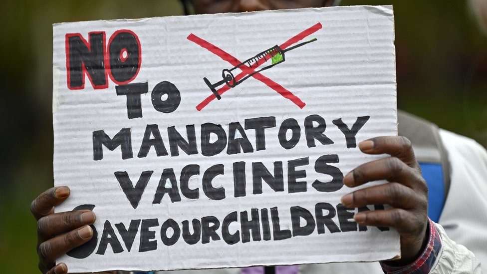 A protester holds up an anti-vaccine placard