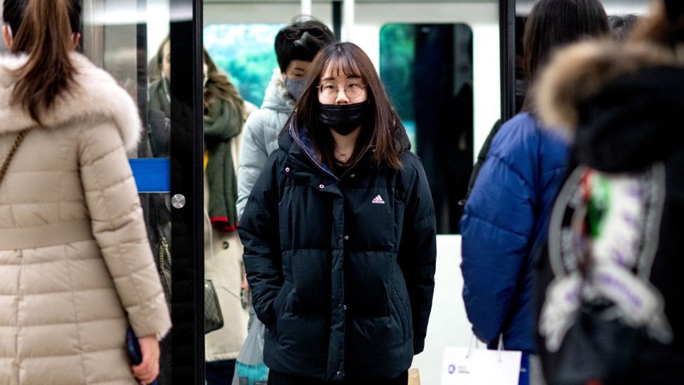 Mujer con mascarilla en el metro de Pekín, China.