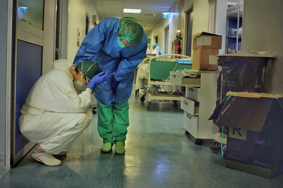 أحد العاملين في المستشفى يواسي زميله في ممر