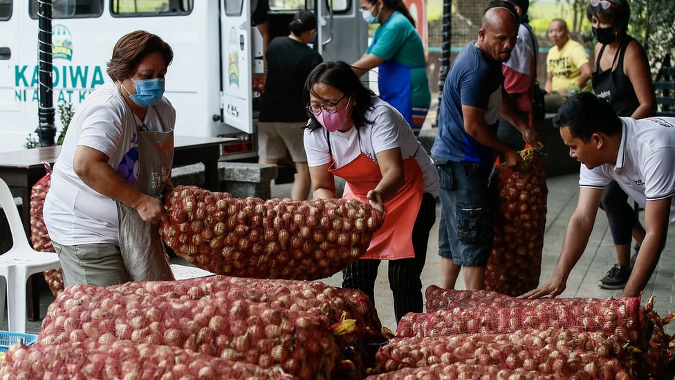 Pessoas carregando sacas de cebola em Quezon City, Metro Manila, Philippines, no dia 10 janeiro de 2023