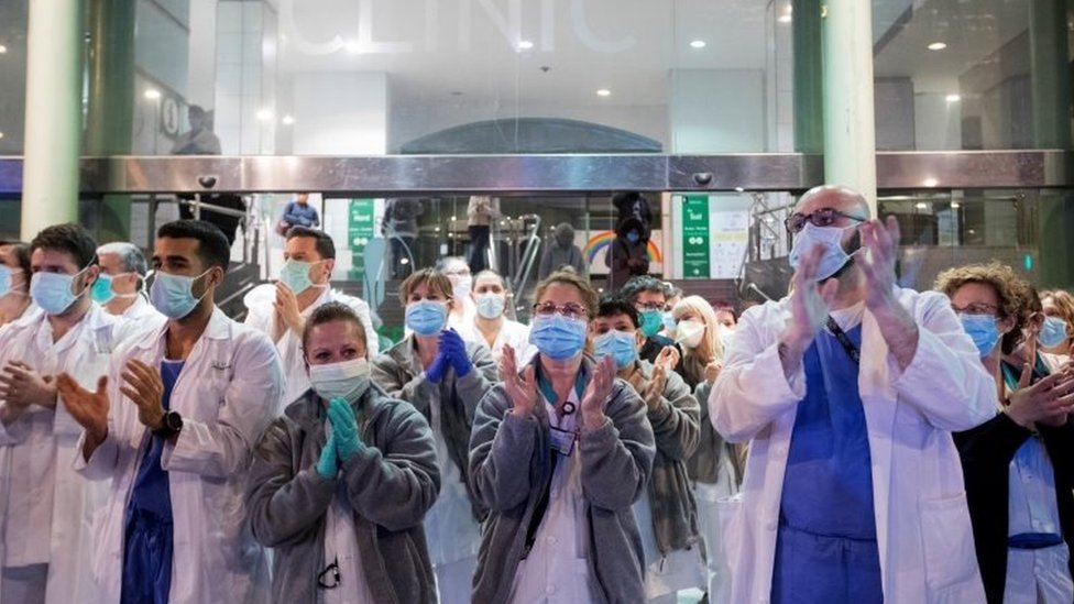 Healthcare workers react during a collective appreciation clapping event in Spain