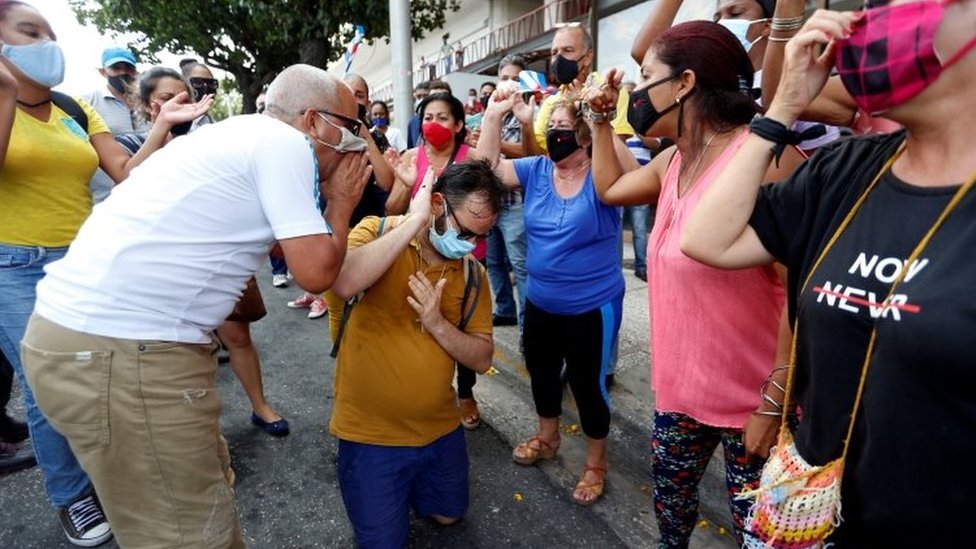 Manifestantes a favor del gobierno gritándole a un opositor