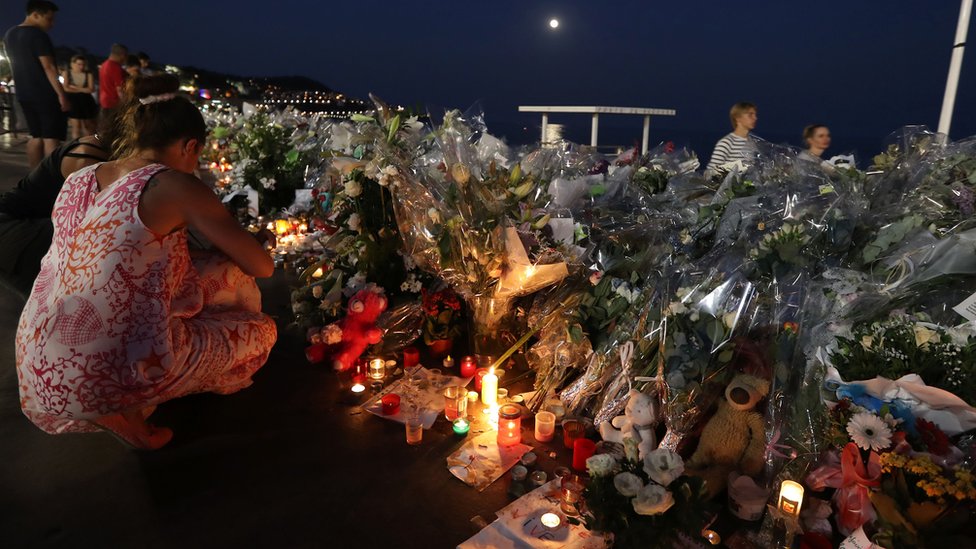 Люди зажигают свечи у импровизированного мемориала на Английской набережной в Ницце 19 июля 2016 г.