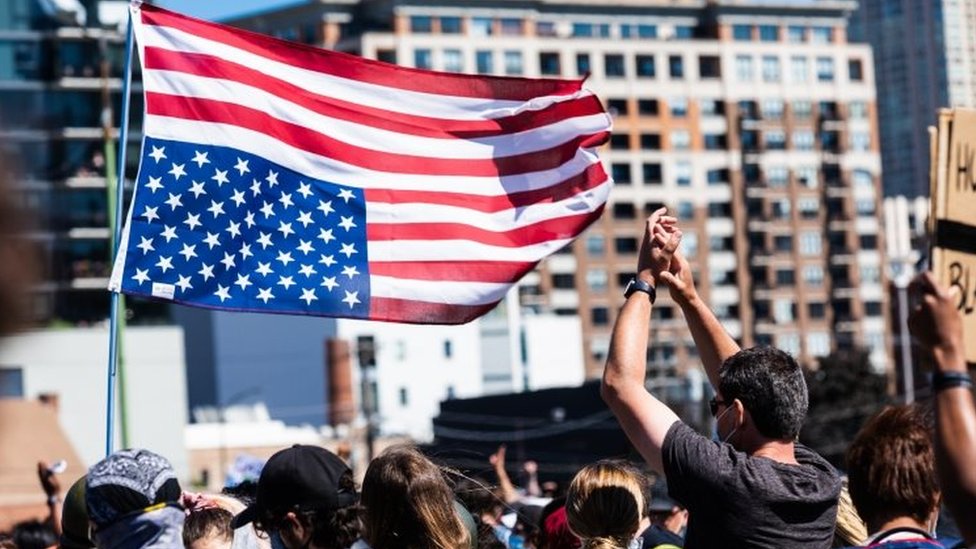Протестующие машут перевернутым флагом США в Чикаго.Фото: 6 июня 2020 г.