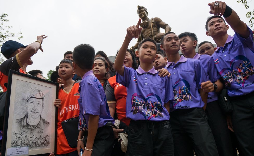 Los niños rescatados ante la estatua del buzo tailandés Saman Gunan.