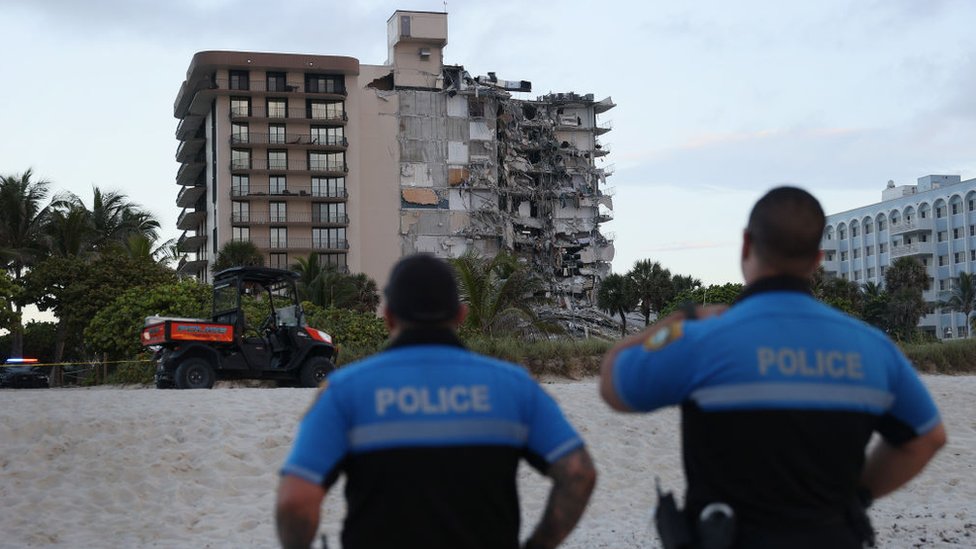 Policías miran el edificio derrumbado.