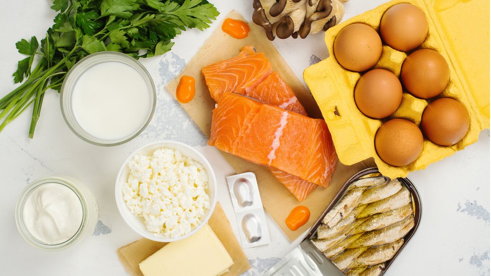 Salmão, ovos, peixe enlatado e outros alimentos que são fonte de vitamina D sobre a mesa