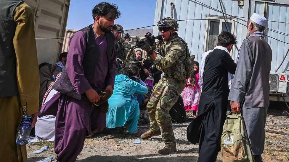 阿富汗喀布爾機場外一名美軍士兵舉槍指嚇一名試圖闖入機場的阿富汗人（16/8/2021）