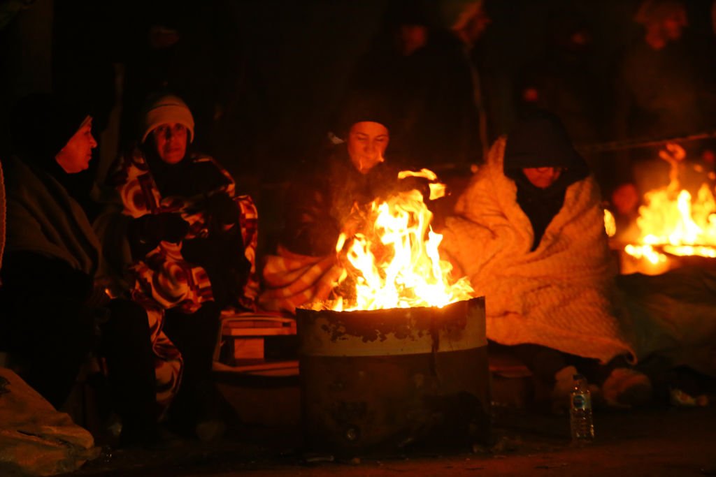 Personas reunidas alrededor de un fuego.
