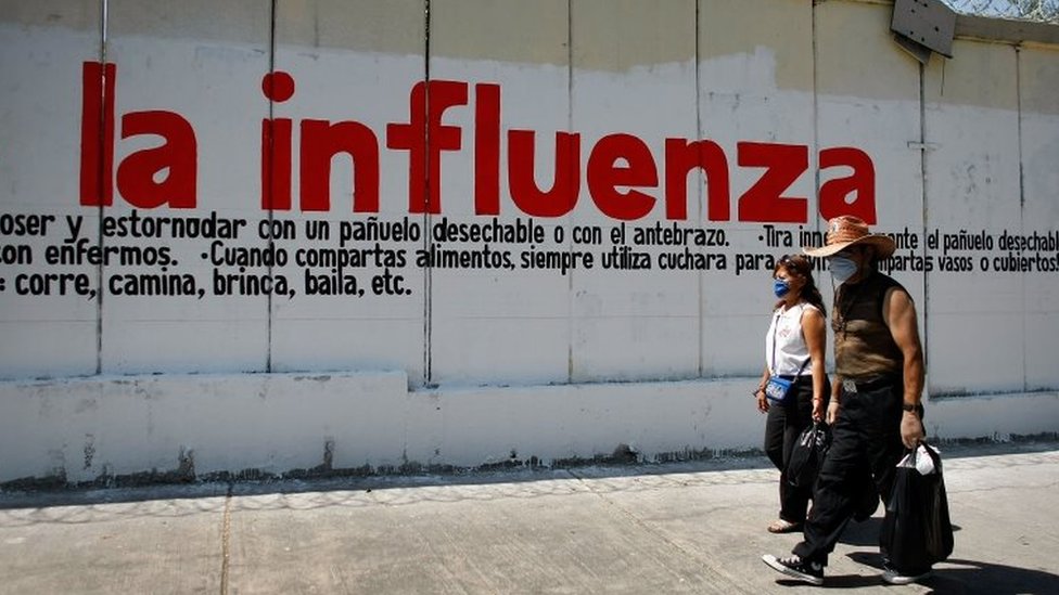 Pessoas diante de mural no México em 2009