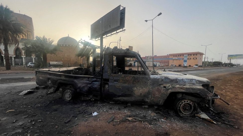 A burned vehicle is seen in Khartoum