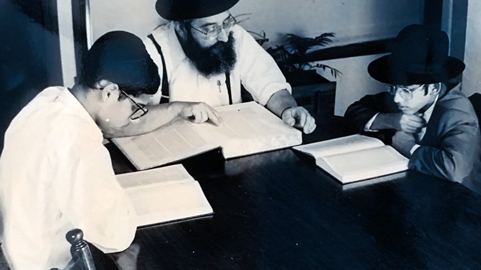 Manny quando criança (à esquerda) estudando religião em casa.