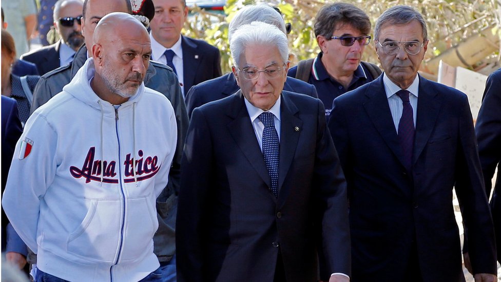 Президент Италии Серджио Маттарелла (в центре) вместе с мэром Аматриче Серджио Пироцци (слева) во время его визита в Аматриче 27 августа 2016 г.