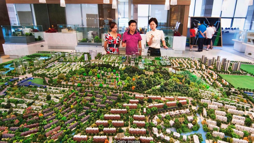 El controvertido programa de visas EB-5 en EE.UU. permite a las personas invertir en proyectos inmobiliarios a cambio de una aplicación rápida de ciudadanía. Personas viendo la maqueta de un proyecto inmobiliario