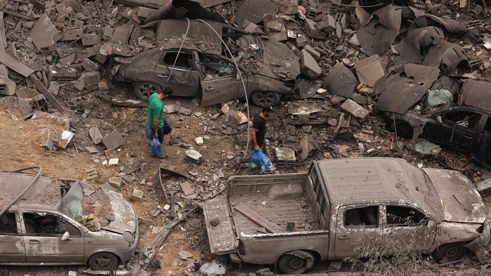 2023年10月9日凌晨，以色列連夜空襲加沙城沙蒂難民營後，一名男子在遭受嚴重轟炸的社區廢墟中行走