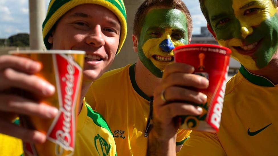 Fans in Brazil shirts drink beer